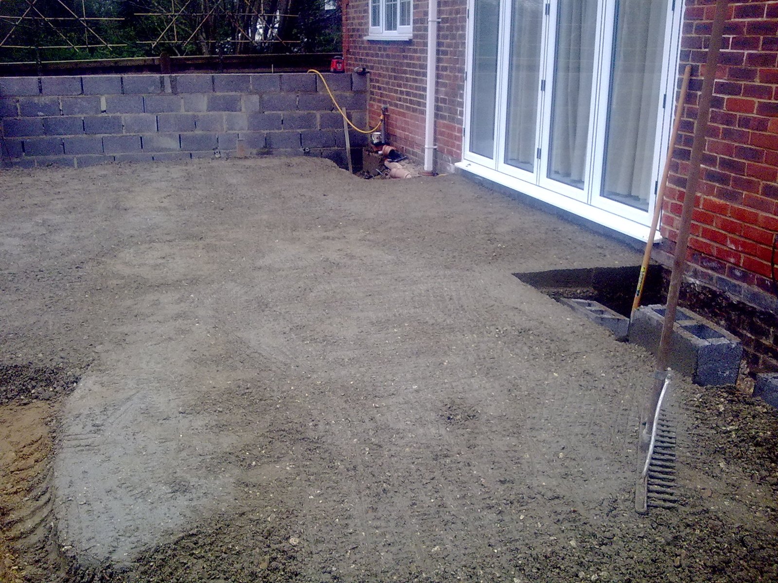 Rendered retaining walls and Indian sandstone patio in Wormley